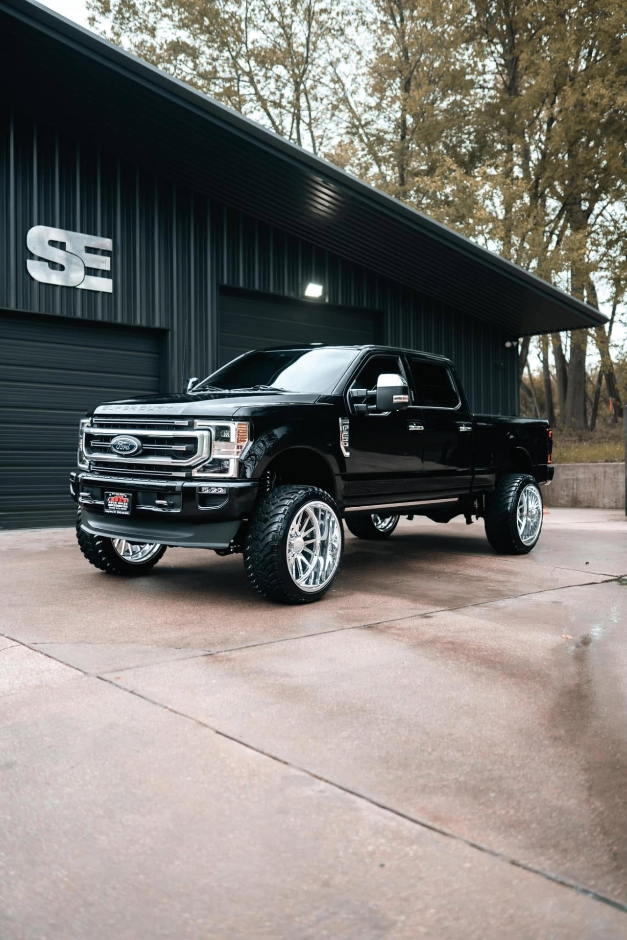car detailing in Longview by SE Auto Solutions — Black Ford Super Duty with polished wheels — lifted truck detail at the SE shop, Longview