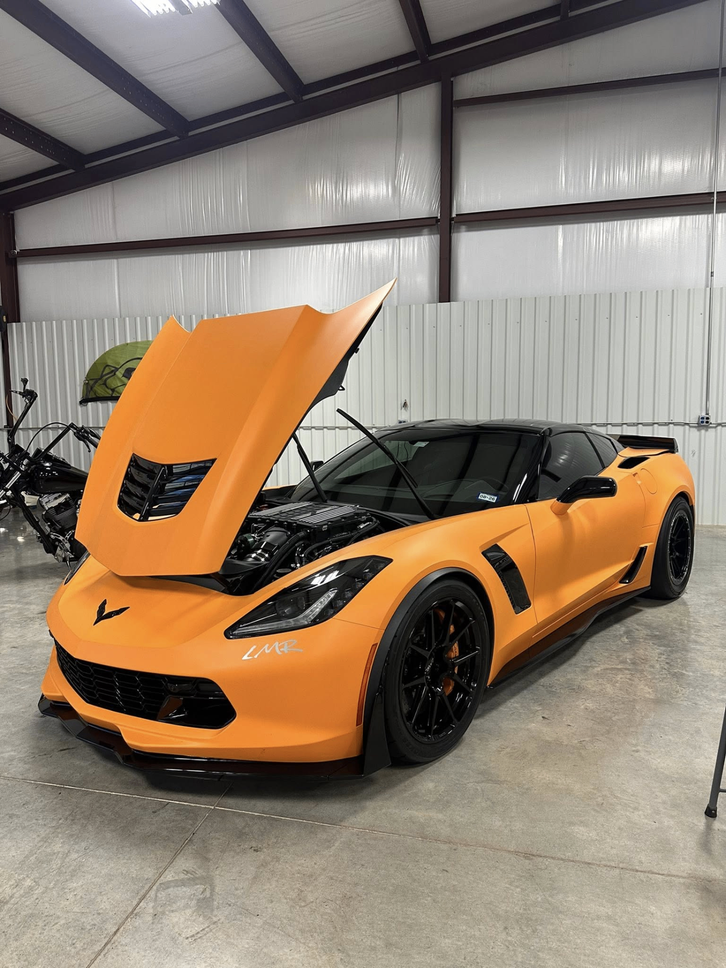 car detailing in Longview by SE Auto Solutions — Orange Corvette with hood open — engine bay and exterior detail, Longview