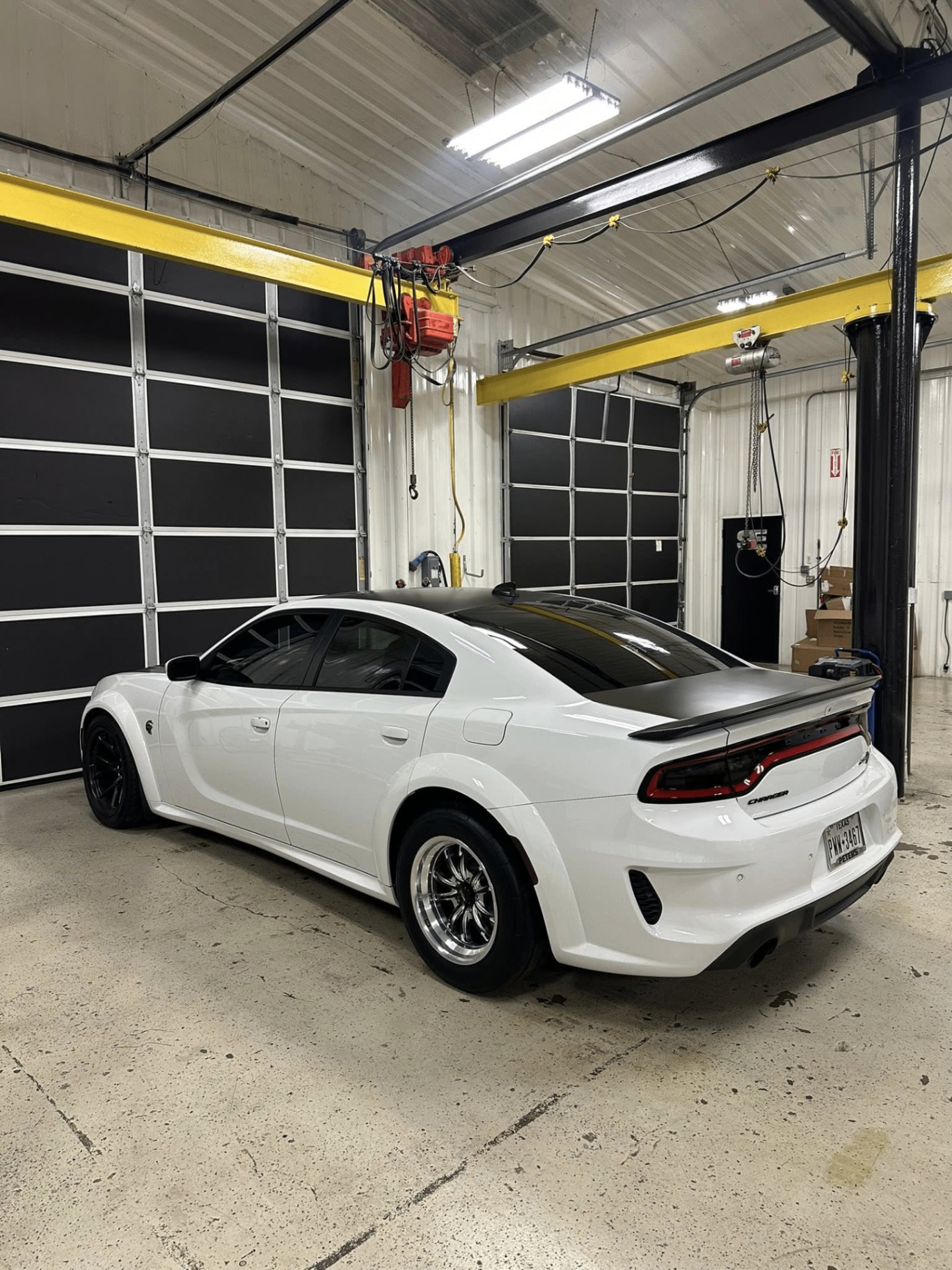 car detailing in Longview by SE Auto Solutions — White Dodge Charger widebody — rear-quarter finish under shop lights, Longview